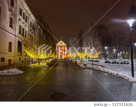 Pathway lined with trees and Capuchin monastery during winter night in city Pathway lined with trees and Capuchin monastery during winter night in city 137331626