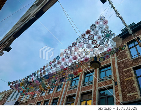 Vibrant circular art instalation hanging from historical building roof in Leuven 137331629