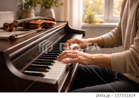 Man Playing Piano at Home with Violin on Wooden Upright Piano in Cozy Sunlit Living Room 137331814