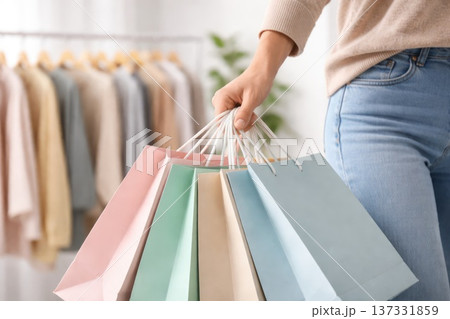 Woman holding colorful shopping bags in clothing store retail shopping concept Woman holding colorful shopping bags in clothing store retail shopping concept 137331859