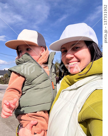 Mother holding toddler outdoors under blue sky Mother holding toddler outdoors under blue sky 137331932
