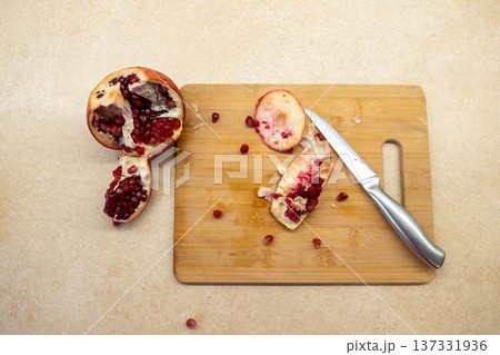 Cut pomegranate on cutting board with knife Cut pomegranate on cutting board with knife 137331936