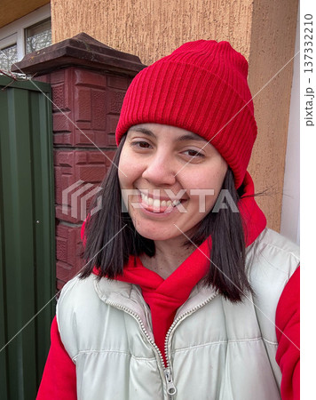 Winter street portrait of woman in red beanie and hoodie Winter street portrait of woman in red beanie and hoodie 137332210