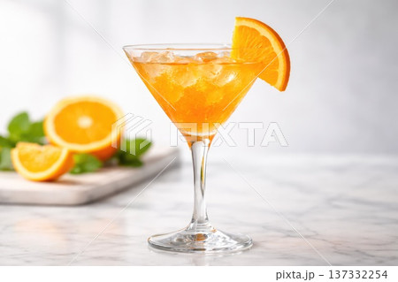 Fresh orange cocktail with ice in martini glass garnished with citrus slice Fresh orange cocktail with ice in martini glass garnished with citrus slice 137332254