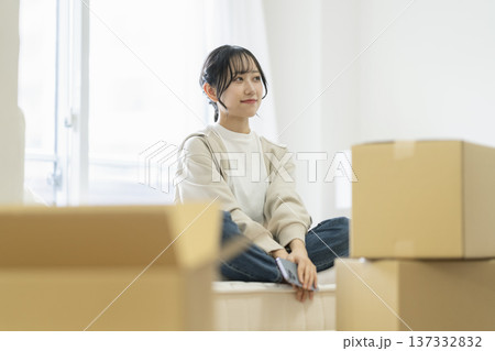 段ボール箱に囲まれて座る若い女性 引っ越し イメージ 段ボール箱に囲まれて座る若い女性 引っ越し イメージ 137332832