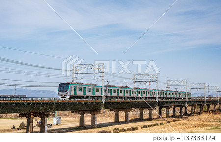 木津川の近鉄京都線鉄橋を渡る京都地下鉄車両　京都府京田辺市 137333124