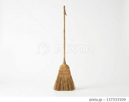 Traditional straw broom with wooden handle, standing upright on a clean white background. Traditional straw broom with wooden handle, standing upright on a clean white background. 137333509