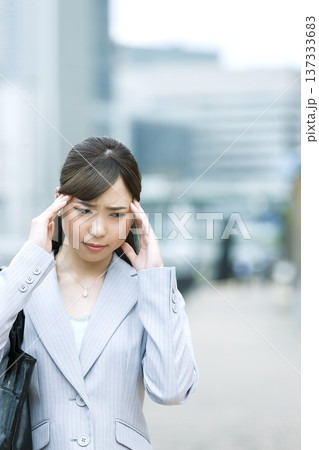 頭を押さえるビジネス ウーマン 頭を押さえるビジネス ウーマン 137333683