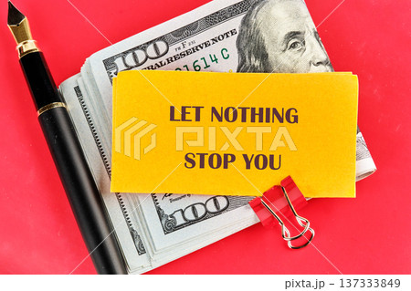 Powerful message on a bold yellow note, surrounded by stacks of hundred dollar bills a fountain pen, on a vivid red background Powerful message on a bold yellow note, surrounded by stacks of hundred dollar bills a fountain pen, on a vivid red background 137333849