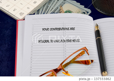 Inspiring message on a notepad, with glasses, pen, calculator, and cash, all on a blue desk Inspiring message on a notepad, with glasses, pen, calculator, and cash, all on a blue desk 137333862
