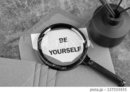 A magnifying glass highlights the phrase be yourself on a paper note A magnifying glass highlights the phrase be yourself on a paper note 137333935