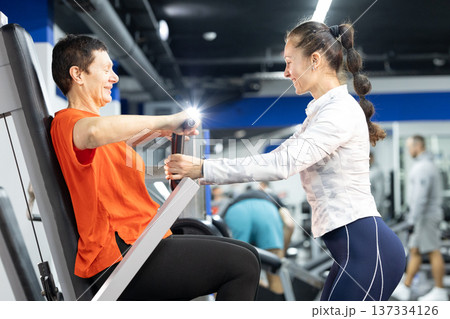 Senior woman training chest press with personal coach Senior woman training chest press with personal coach 137334126