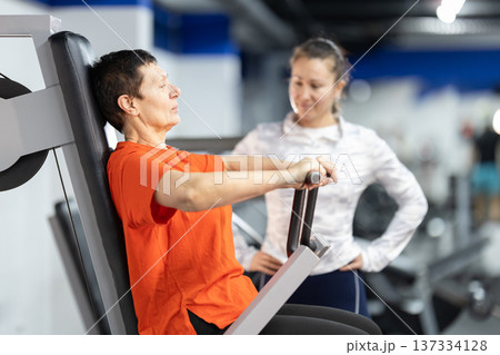 Senior woman training with personal coach in gym Senior woman training with personal coach in gym 137334128