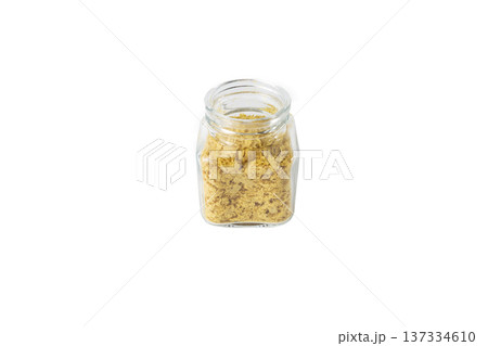 Savoury vegan yeast flakes in a glass jar isolated on white background. Savoury vegan yeast flakes in a glass jar isolated on white background. 137334610