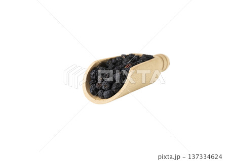 Dried Aronia or black chokeberry - Aronia melanocarpa in latin in wooden scoop isolated on white background. 137334624