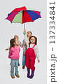 Girls under colorful umbrella wearing mid season rainwear kids fashion outfits in studio 137334841