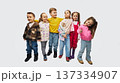 Group of children standing together wearing colorful mid season kids fashion outfits in studio 137334907