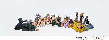 Group of children lying on floor in row wearing mid season kids fashion outfits in studio. Banner Group of children lying on floor in row wearing mid season kids fashion outfits in studio. Banner 137334908