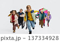 Children running together wearing bright kids outfits in white studio. 137334928
