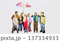 Group of children looking up under colorful umbrella wearing mid season kids fashion clothing. 137334933