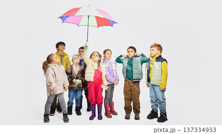 Group of children looking up under colorful umbrella wearing mid season kids fashion clothing. Group of children looking up under colorful umbrella wearing mid season kids fashion clothing. 137334933