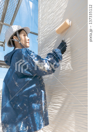 外壁塗装の現場で働く女性職人:住宅リフォームと足場作業のプロフェッショナル 外壁塗装の現場で働く女性職人:住宅リフォームと足場作業のプロフェッショナル 137335112