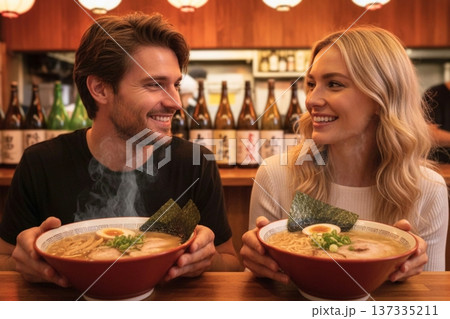 日本の居酒屋で湯気の立つ本格的なラーメンを楽しむ外国人カップル 137335211