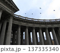 The colonnade of the Kazan Cathedral with ornate architectural details in St. Petersburg. View of the Kazan Cathedral and the sky with pigeons from a low angle, St. Petersburg, Russia. 137335340