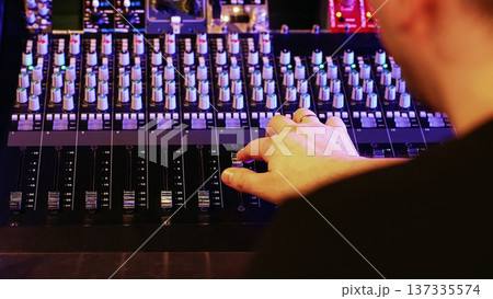 Sound Engineer Adjusts Faders, Hand Moves Controls. Music Production, Modern Studio, Creative Process, Concert Setup. 137335574