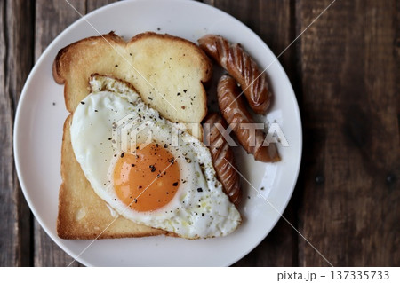 目玉焼きを乗せたトーストと粗挽きウインナー 137335733