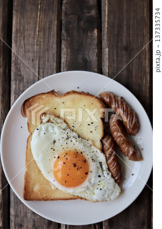 目玉焼きを乗せたトーストと粗挽きウインナー 137335734