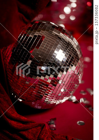 Shiny disco ball on red background with festive reflections Shiny disco ball on red background with festive reflections 137336082