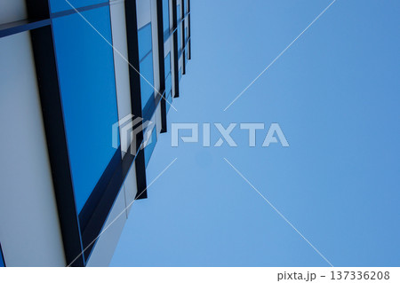 Part of modern industrial office building exterior facade with the background of a blue sky. Urban architecture , property element detail. Business center, financial district architecture Part of modern industrial office building exterior facade with the background of a blue sky. Urban architecture , property element detail. Business center, financial district architecture 137336208
