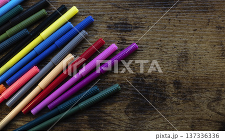 Colorful markers scattered on wooden background 137336336
