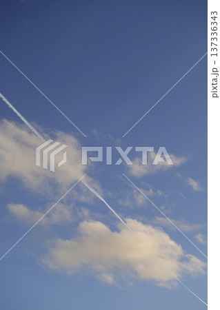 Airplane trail in the blue sky, white clouds on a sunny day Airplane trail in the blue sky, white clouds on a sunny day 137336343