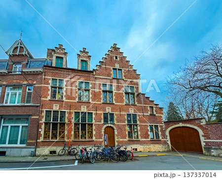 Charming old red brick building in Leuven surrounded by trees and bicycles Charming old red brick building in Leuven surrounded by trees and bicycles 137337014
