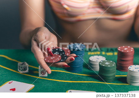 Woman Holding Poker Chips at Casino Table with Colorful Chips and Playing Cards for Gambling Lifestyle and Entertainment Concept Woman Holding Poker Chips at Casino Table with Colorful Chips and Playing Cards for Gambling Lifestyle and Entertainment Concept 137337138