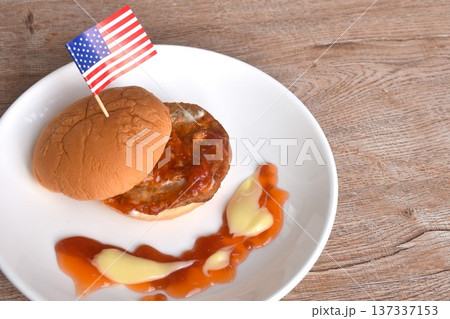 fried mashed pork hamburger with Italian tomato sauce stick USA flag dressing mayonnaise on plate 137337153
