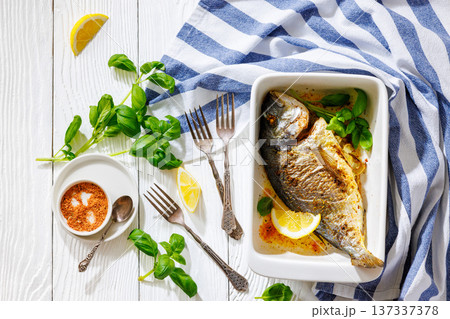 Baked whole dorada fish with lemon and basil 137337378