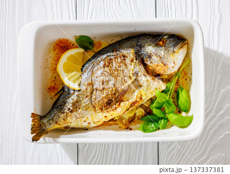 Baked whole dorada fish with lemon and basil Baked whole dorada fish with lemon and basil 137337381