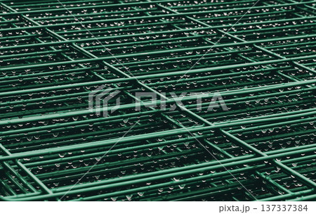 Metal grille with water droplets glistening. Rainy atmosphere, perfect for urban or industrial themes. Suggests freshness, renewal, or quiet moments. Ideal for backgrounds, mood boards, or design 137337384