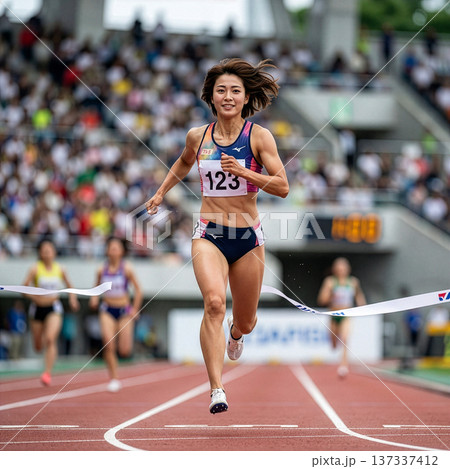 陸上競技場でゴールする若い女性 137337412