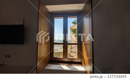 Aegean Sea and white townscape under the blue sky seen through wooden window Aegean Sea and white townscape under the blue sky seen through wooden window 137338895