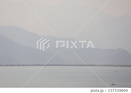 朝もやで霞む空と山並みと湖の風景 朝もやで霞む空と山並みと湖の風景 137339009