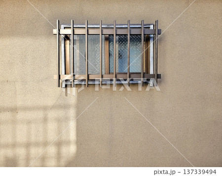 Bronze colored aluminum window security grate installed over a window on wall in Japanese style. Bronze colored aluminum window security grate installed over a window on wall in Japanese style. 137339494