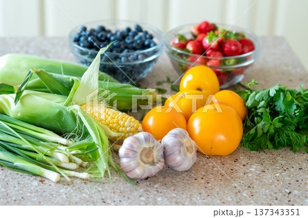Fresh vegetables and berries on kitchen counter in natural light Fresh vegetables and berries on kitchen counter in natural light 137343351