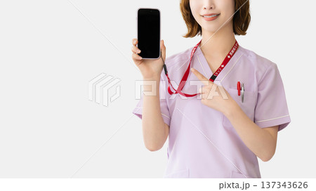 スマートフォンを指差す笑顔の女性医療スタッフ スマートフォンを指差す笑顔の女性医療スタッフ 137343626