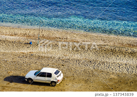 Car and fishing pole at the shore of sea. Car and fishing pole at the shore of sea. 137343839