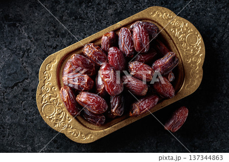 Dates fruits on black stone table. 137344863