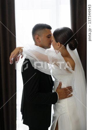 Groom kissing bride on forehead while embracing Groom kissing bride on forehead while embracing 137344943